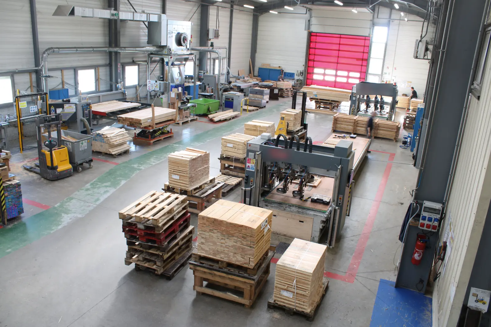 Vue plongeante de l’atelier de Propières : ligne de clouage, postes de montage, palettes prêtes